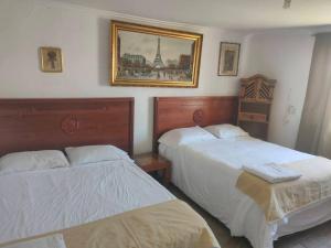 1 dormitorio con 2 camas y una foto en la pared en Beautiful Rustic Cottage Adobe, Rancho El Payasito en Cuauhtémoc