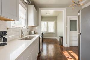 una cucina bianca con lavandino e finestra di Luxurious 6 bedroom villa near downtown a San Antonio