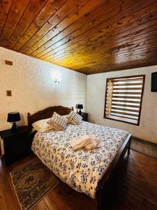 a bedroom with a bed with a wooden ceiling at Cabañas Santa Rita in Cobquecura