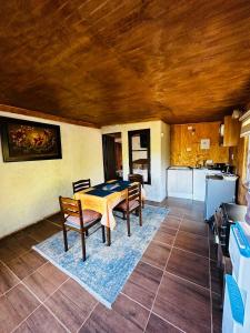 ein Esszimmer mit einem Tisch und Stühlen sowie eine Küche in der Unterkunft Cabañas Santa Rita in Cobquecura