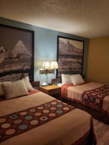 una habitación de hotel con 2 camas y un cuadro en la pared en Super 8 by Wyndham Raton, en Ratón