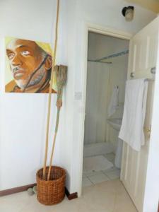 a bathroom with a painting of a man at Selen's Apartment in Ti Rocher Micoud Saint Lucia in Micoud