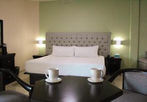 - une chambre avec un lit et une table avec deux tasses dans l'établissement Hotel Mirage, à La Piedad Cavadas