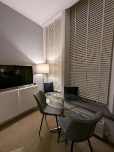 un soggiorno con tavolo e sedie in vetro di 1 Bed Apartment - Sea view a Shanklin