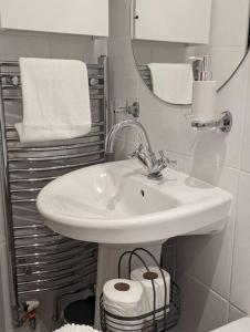 a bathroom with a sink and a mirror and towels at 1 Bed Apartment - Sea view in Shanklin