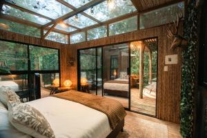 a bedroom in a tree house with a glass wall at BubbleSky Glamping Guatapé in Guatapé