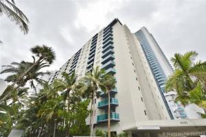 a tall white building with palm trees in front of it at Beautiful penthouse condo with stunning views of both ocean and city in Hollywood