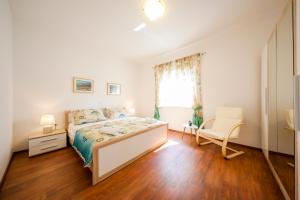 ein Schlafzimmer mit einem Bett, einem Stuhl und einem Fenster in der Unterkunft Holiday home ''Villa Galetta'' in Ist