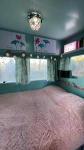 - une chambre avec un lit rose dans une pièce dotée de fenêtres dans l'établissement Ir por ai Arrábida, à Azeitão