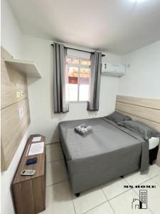 Dormitorio pequeño con cama y mesa en MSHome - Apartamento Térreo com Varanda e Mobiliado en João Pessoa