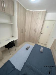 een slaapkamer met een blauw bed en een bureau bij MSHome - Apartamento Térreo com Varanda e Mobiliado in João Pessoa