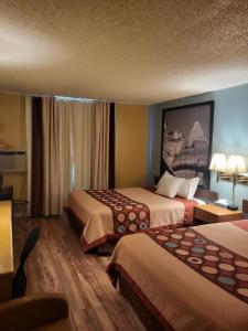 una habitación de hotel con 2 camas en una habitación en Super 8 by Wyndham Raton, en Ratón