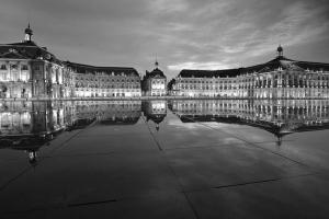 une photo en noir et blanc d'un bâtiment avec une tour d'horloge dans l'établissement Lovely, à Bordeaux