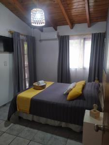 ein Schlafzimmer mit einem blauen Bett und gelben Kissen in der Unterkunft Hotel Alta Mendoza in Mendoza