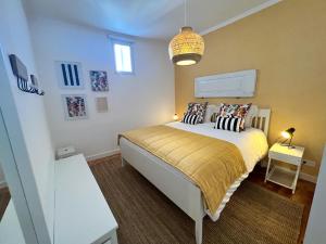 a bedroom with a bed and a pendant light at Madre de Deus, 5 - Terrace in Évora