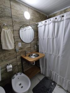 a bathroom with a sink and a white shower curtain at Bahía de cimarrones in Dolores