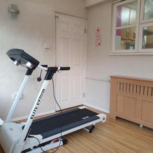 een kamer met een fitnessruimte met een loopband en een deur bij Ideally located contemporary 3 bed spacious house in Wainscot