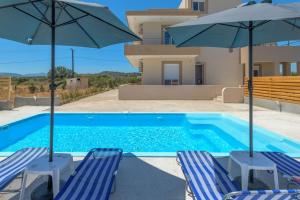 - une piscine avec 2 chaises longues et 2 parasols dans l'établissement Kolymbia Breeze: Hilltop Oasis, Fantastic Sea Views, à Afantou