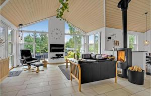 a living room with a couch and a fireplace at Stunning Home In Fars With Sauna in Hvalpsund