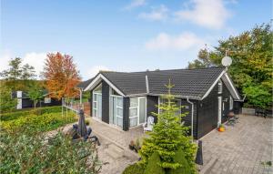 una casa con una casa nera con cortile di Stunning Home In Fars With Sauna a Hvalpsund