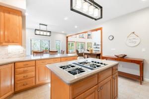 une cuisine avec des armoires en bois et un four à plaques de cuisson dans l'établissement Lakeside Retreat, à Brevard