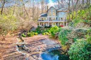 une grande maison avec une rivière en face dans l'établissement Lakeside Retreat, à Brevard