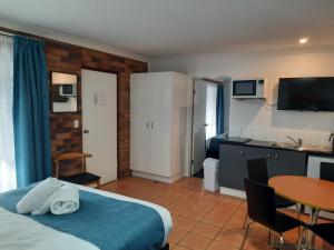 a hotel room with a bed and a table at Cleveland Motor Inn in Cleveland