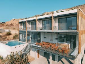 una imagen de un edificio con piscina y sillas en Eolia Sustainable Design Hotel, en Manta