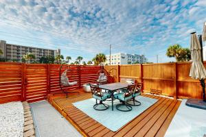 une terrasse en bois avec une table et des chaises dessus dans l'établissement Sugar Reef Cottage #4, à Fort Walton Beach