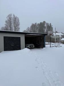 un garaje con un coche aparcado en la nieve en Säfsen Stay, en Ludvika