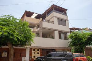 a house with cars parked in front of it at Confortable APT-Estudio con WIFI,Neflix y PKG Gratis in Lima