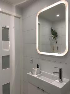 La salle de bains blanche est pourvue d'un lavabo et d'un miroir. dans l'établissement New Modern apartment in the heart of city center Delft, à Delft