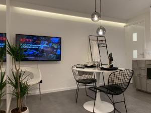 a kitchen with a table and chairs and a tv on the wall at New Modern apartment in the heart of city center Delft in Delft