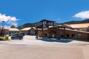 un estacionamiento frente a un edificio con una señal de estacionamiento en Best Western Golden Spike Inn & Suites, en Hill City