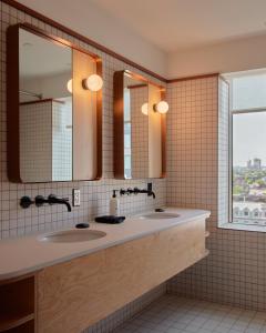 a bathroom with two sinks and two mirrors at Ace Hotel Toronto in Toronto