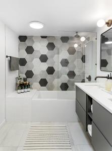 een badkamer met een bad, een wastafel en een douche bij The Maple House in Seattle