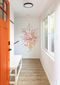 an orange door in a hallway with a painting on the wall at The Maple House in Seattle