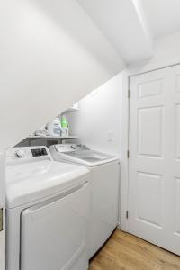 a white laundry room with a washer and dryer at The Maple House in Seattle