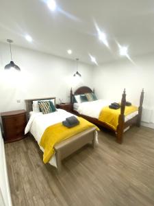 1 Schlafzimmer mit 2 Betten mit gelben Decken und Lichtern in der Unterkunft Wild Atlantic Way Beach Cove View Ballyara in Killybegs