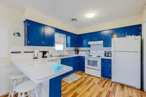 a kitchen with blue cabinets and a white refrigerator at Rehoboth Beach Anna B St in Rehoboth Beach