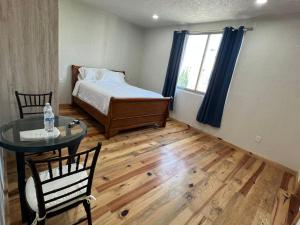 1 dormitorio con cama, mesa y ventana en CASA EL CHALET en Morelia