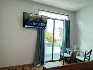 sala de estar con ventana grande y TV en CASA EL CHALET en Morelia