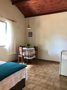 een kamer met een tafel en stoelen en een tafel en een raam bij Hotel Chalés Gramado in Águas de Santa Barbara