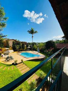 einen Blick vom Balkon eines Hauses mit Pool in der Unterkunft Hotel Chalés Gramado in Águas de Santa Barbara