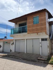 a house with a balcony on top of it at Casa 3quartos rota Maragogi Carneiros in São José da Coroa Grande