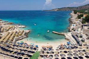 an aerial view of a beach with umbrellas and the ocean at Full Moon Apartments in Ksamil