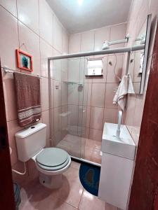 a pink bathroom with a toilet and a shower at Apto Aconchego da aldeia 02 ap08 in São Pedro da Aldeia