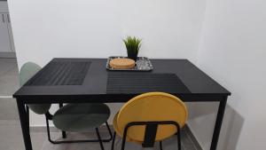 einem schwarzen Tisch mit gelben Stühlen und einem Teller mit Essen in der Unterkunft Studio Apartment 12 Minutes from Bahai's garden in Haifa