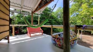 格蘭特島的住宿－El Hamaquero Hostal EcoNativo，一个带吊床和红色椅子的门廊
