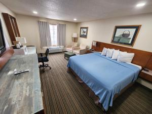 Habitación de hotel con cama grande y escritorio. en Windsor Place Inn en Prairie du Chien